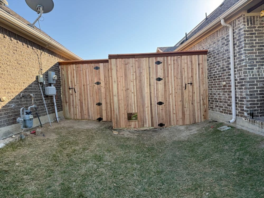 Wooden storage shed in a residential backyard with grass and brick walls.