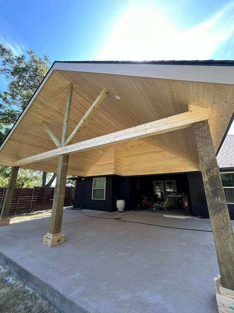 Modern covered patio with wooden beams and a sleek design, showcasing outdoor living space.